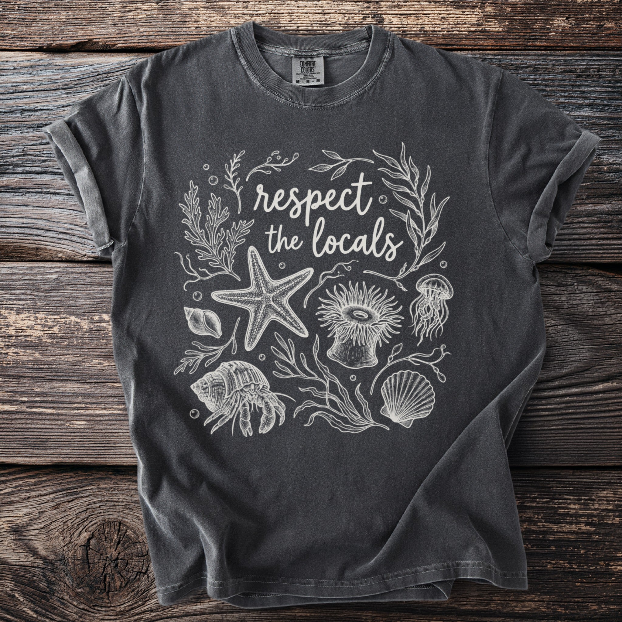 Dark grey t-shirt with white line art: "respect the locals" and marine life.