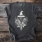 Dark gray t-shirt with witch hat, crescent moon, and botanical illustration design.