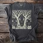 Dark t-shirt with a cream linocut design of three faces emerging from trees and foliage.