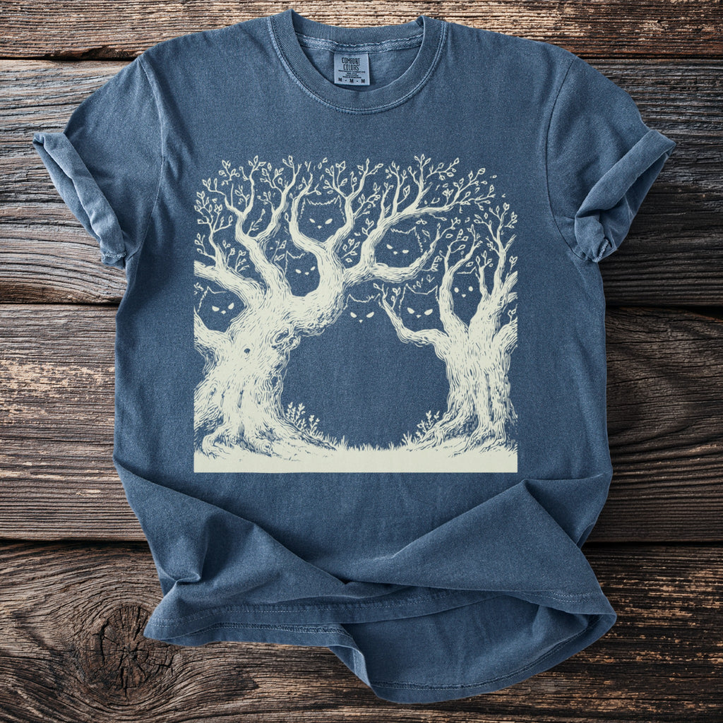 T-shirt with a cream-colored illustration of spooky trees with cat faces hidden in branches.