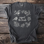 Dark gray t-shirt with white line art of birds and floral elements. Text reads "respect the locals."