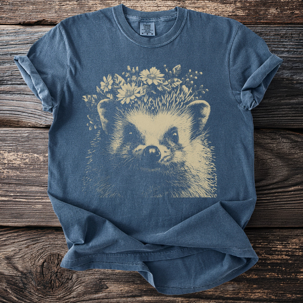 Blue t-shirt with a cream-colored hedgehog wearing a flower crown, Comfort Colors tag.