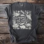 Dark grey t-shirt with "respect the locals" text and wildlife illustration.