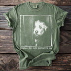 Green t-shirt with a distressed print of a dog peeking out and text saying "please do not perceive me".