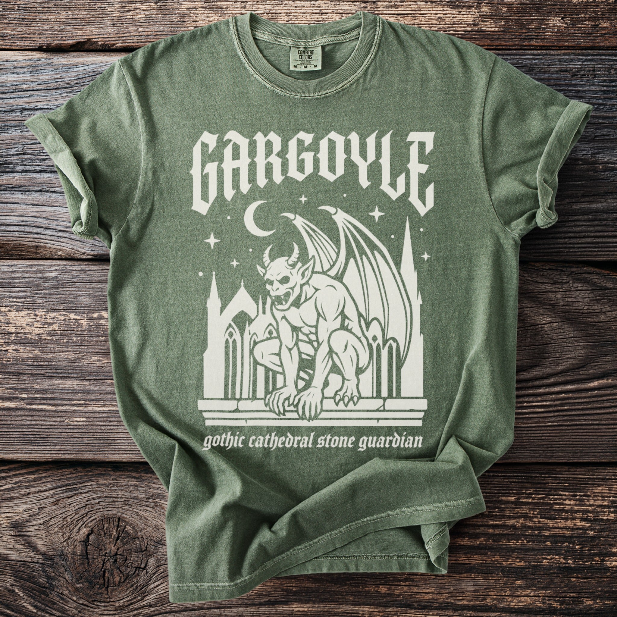 Muted green t-shirt with white "Gargoyle" text and gothic cathedral stone guardian graphic.