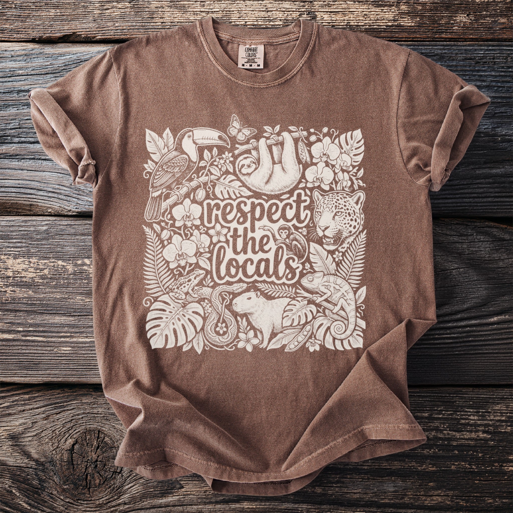 Brown t-shirt with white print of jungle animals and text "respect the locals".