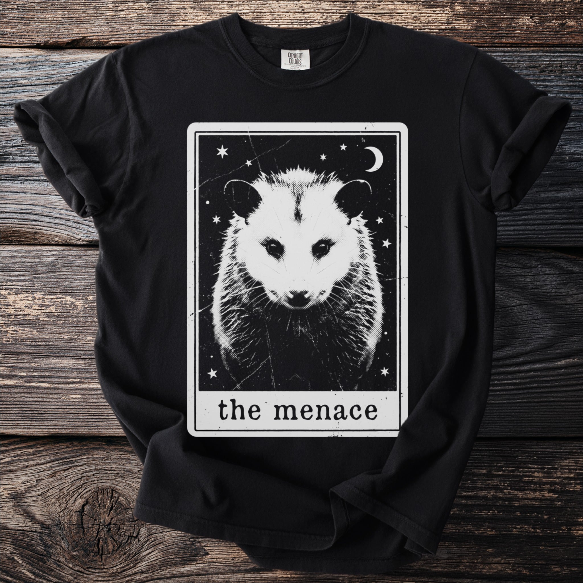 Black t-shirt with a tarot-style graphic of an opossum and the text "the menace."