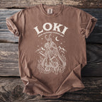 Brown t-shirt with white graphic of Loki, mountains, fire, and snakes.