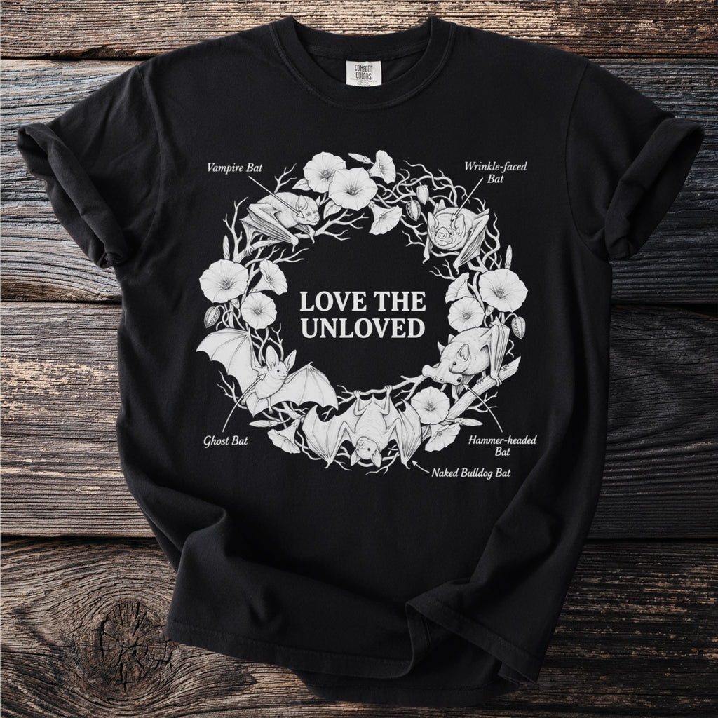 Black t-shirt with white line art of bats and flowers, text "LOVE THE UNLOVED".