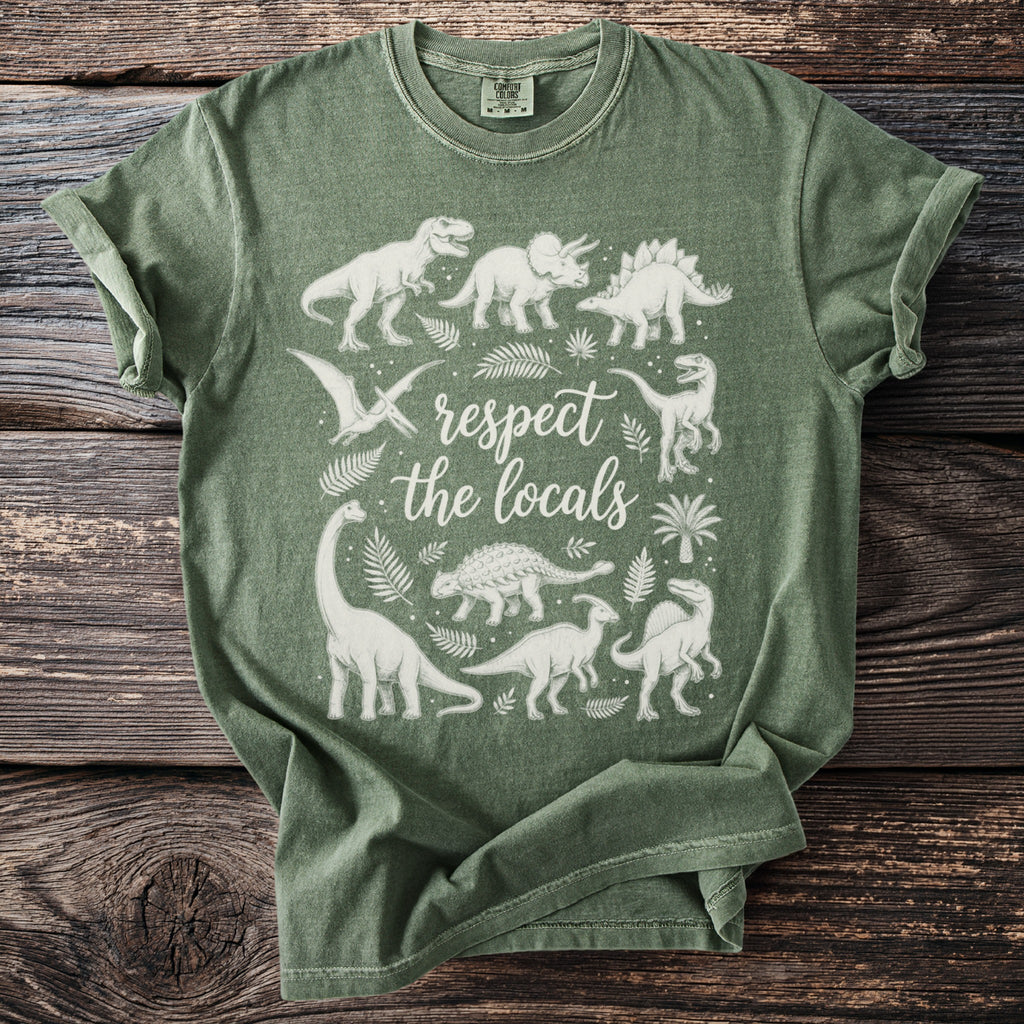 Green t-shirt with white line art of various dinosaurs and plants, and text "respect the locals".