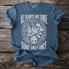 Blue t-shirt with white graphic of a skull, plants, and text "ALL PLANTS ARE EDIBLE SOME ONLY ONCE".