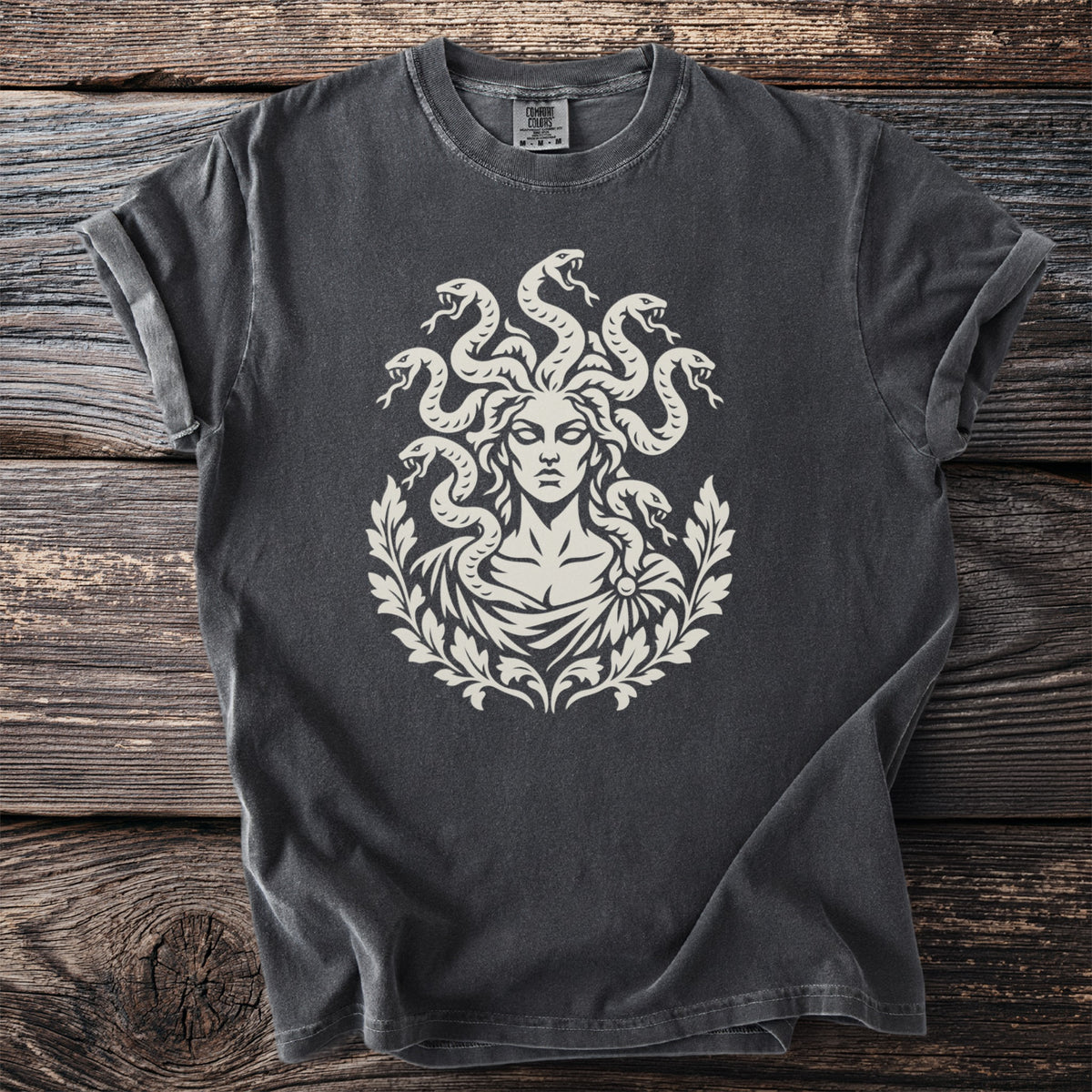 Charcoal t-shirt with a cream graphic of Medusa surrounded by snakes and laurel leaves.