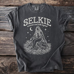 Dark gray t-shirt with white graphic: "SELKIE scottish seal folk legend" above a sitting mythical figure.