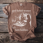 Brown t-shirt with "god forbid women have hobbies" and witchcraft graphic.