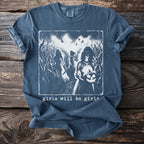 Blue t-shirt with spooky graphic of figures in a cornfield and text "girls will be girls."