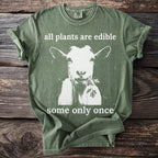 Green t-shirt with goat eating greens and text "all plants are edible some only once".