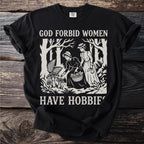 Black shirt with "God Forbid Women Have Hobbies" text and forest scene illustration.