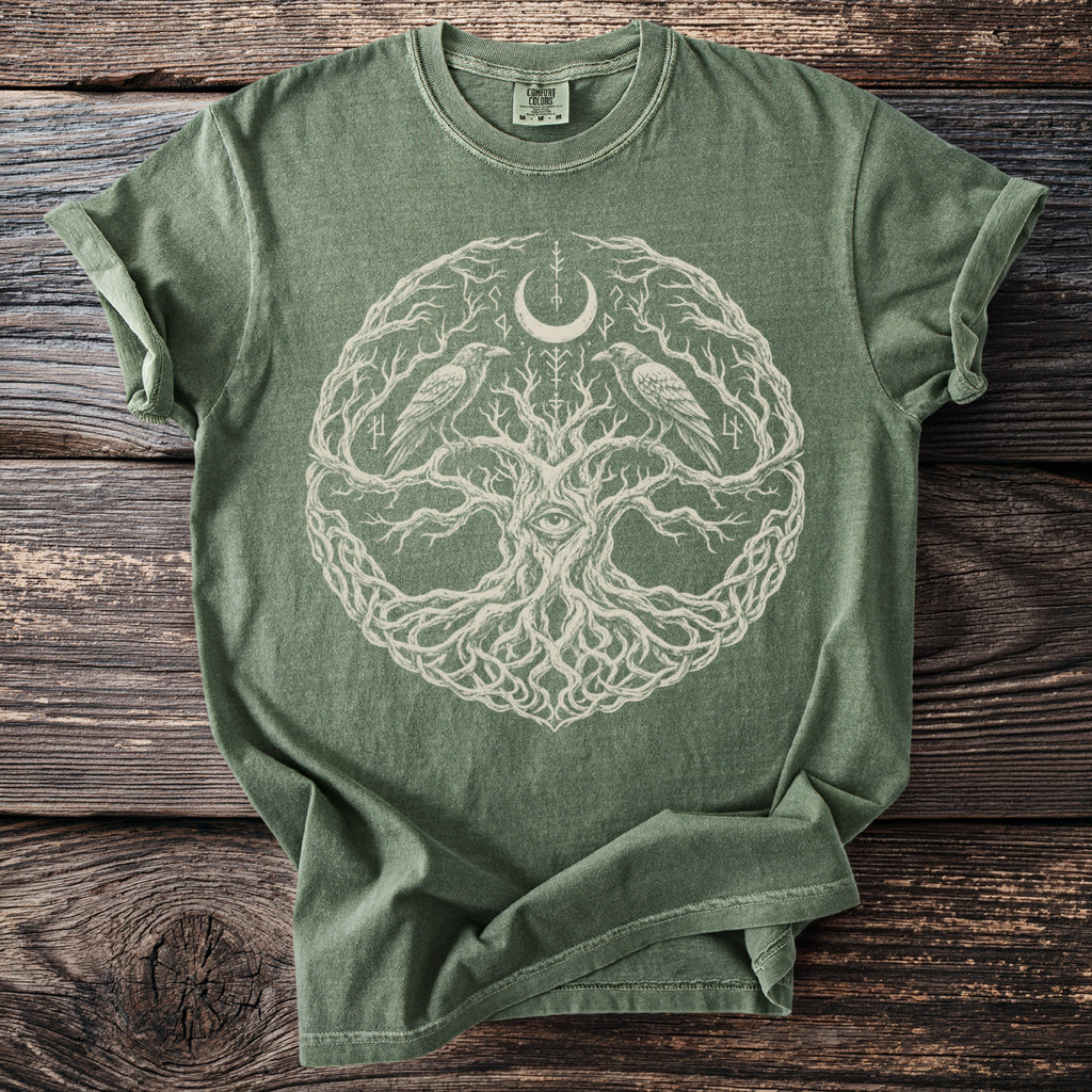 Olive green t-shirt with a central circular design of a tree, eye, moon, and ravens.