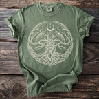Olive green t-shirt with a central circular design of a tree, eye, moon, and ravens.