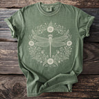 Green t-shirt with a white line drawing of a dragonfly in a floral wreath.
