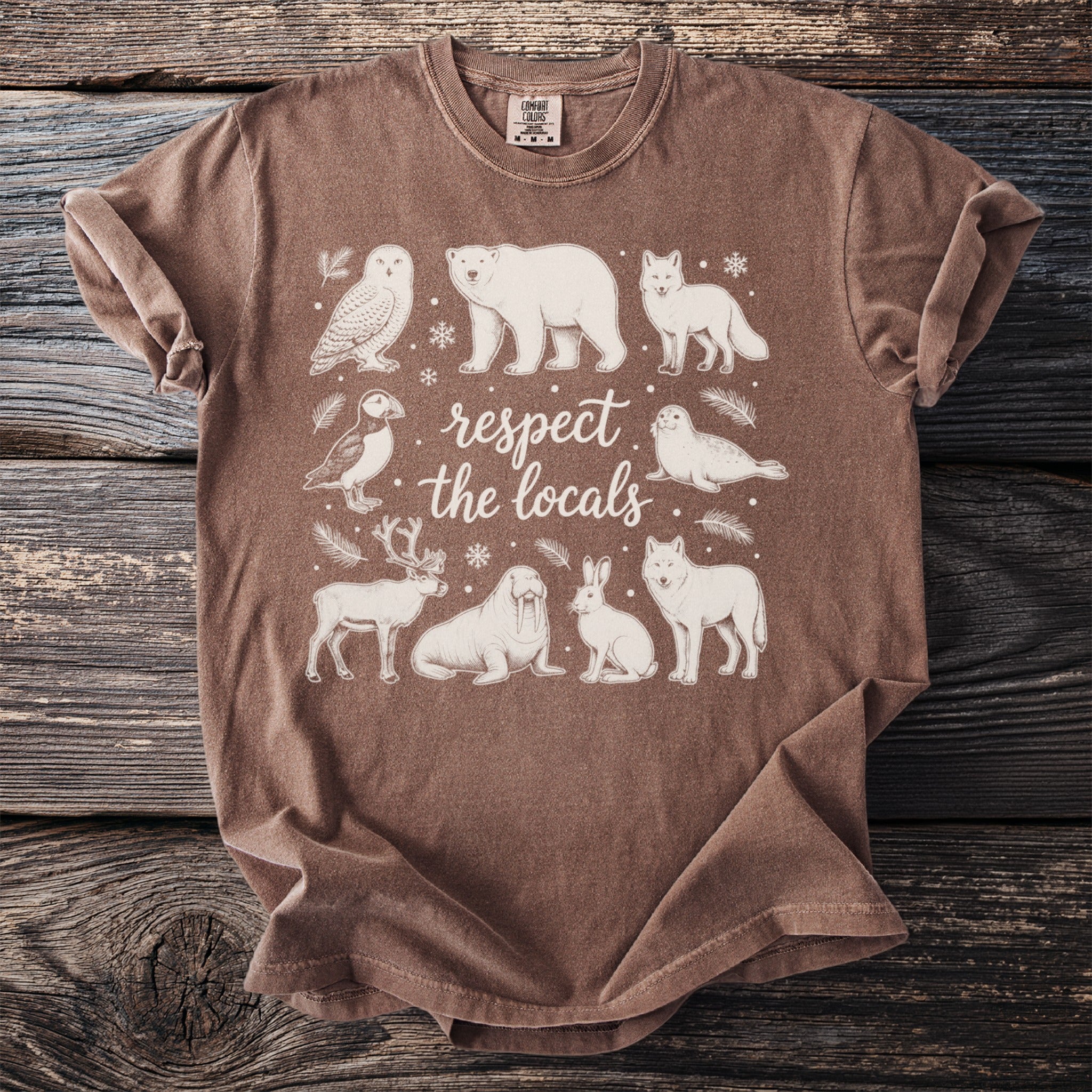 Brown t-shirt with white line art of Arctic animals and text "respect the locals".