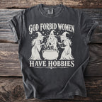 Graphic tee with "God Forbid Women Have Hobbies" and three witches by a cauldron.