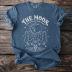 Blue t-shirt with "THE MOON tarot card arcana lunar mystery" graphic.