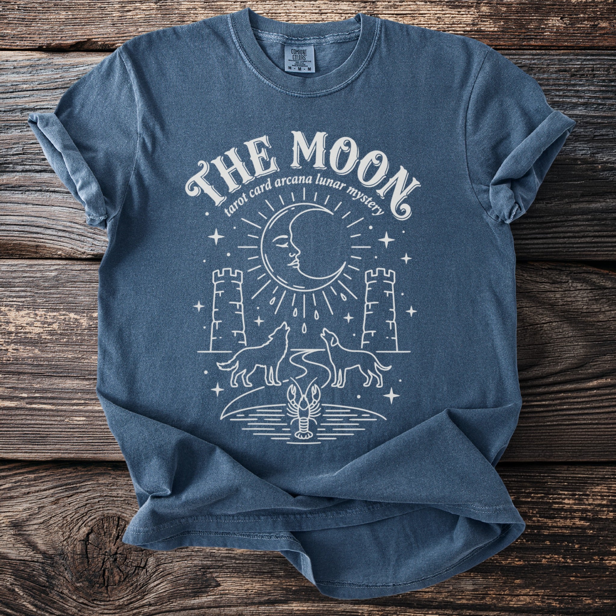 Blue t-shirt with "THE MOON tarot card arcana lunar mystery" graphic.