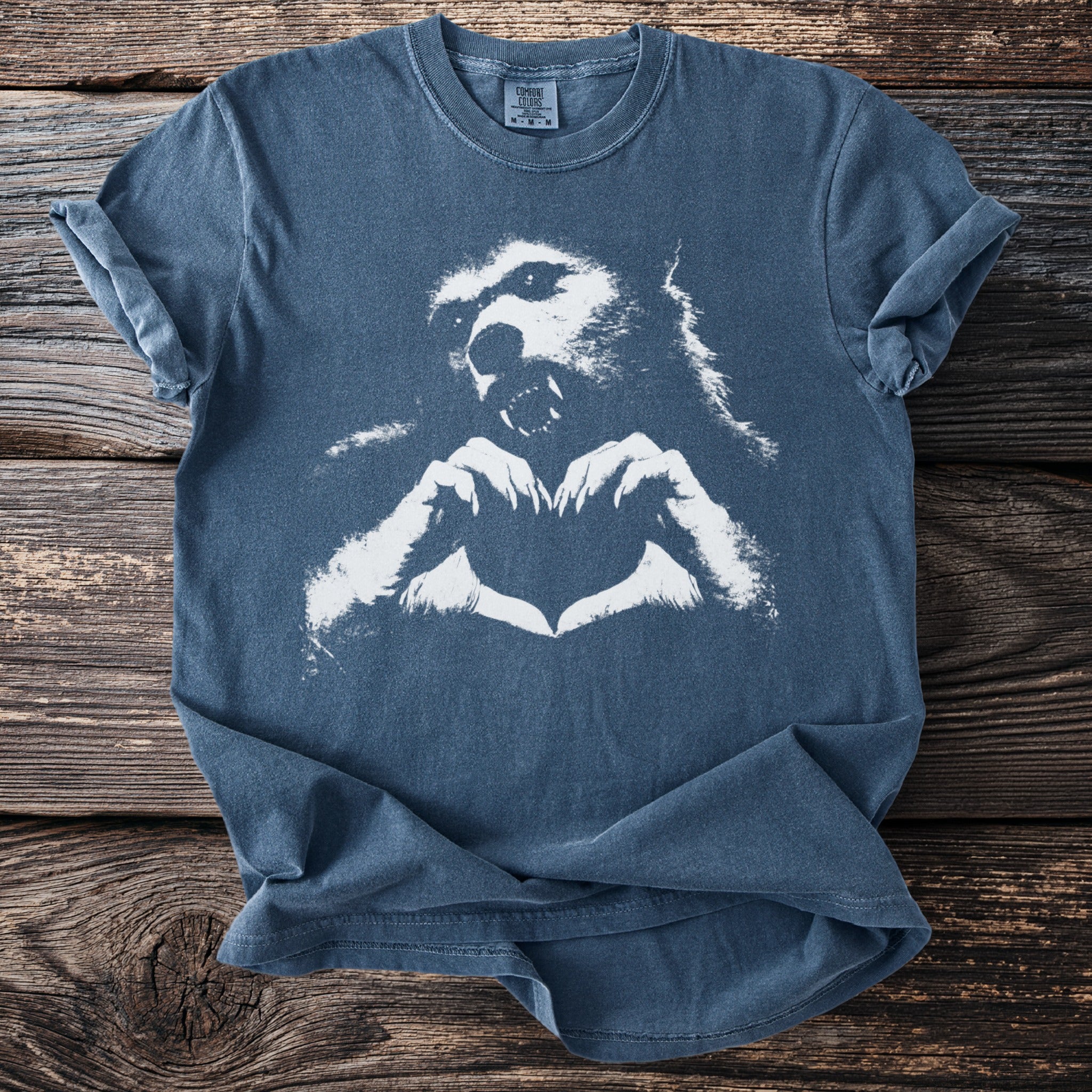 Blue t-shirt with white werewolf head making heart shape with paws.