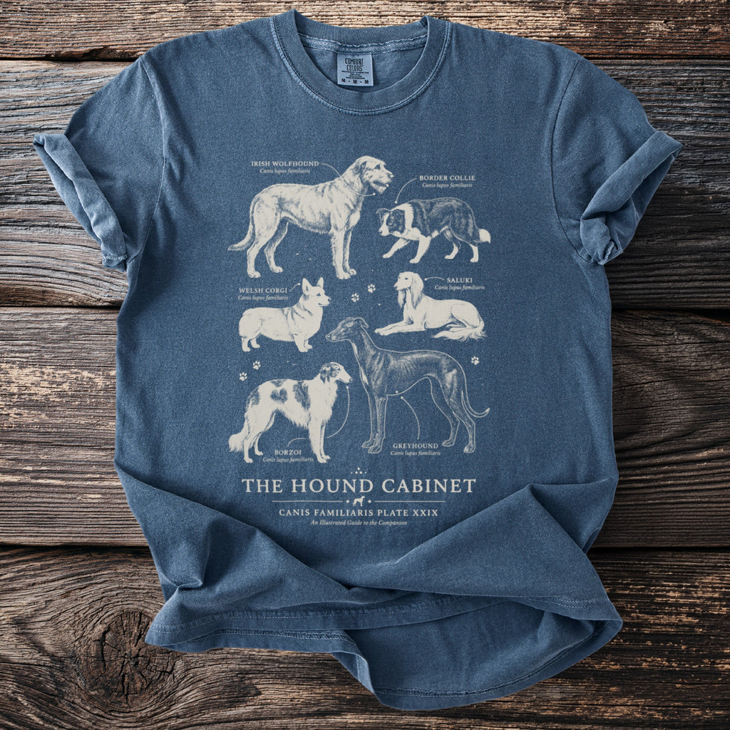 Blue t-shirt featuring an illustration of six dog breeds titled "The Hound Cabinet".