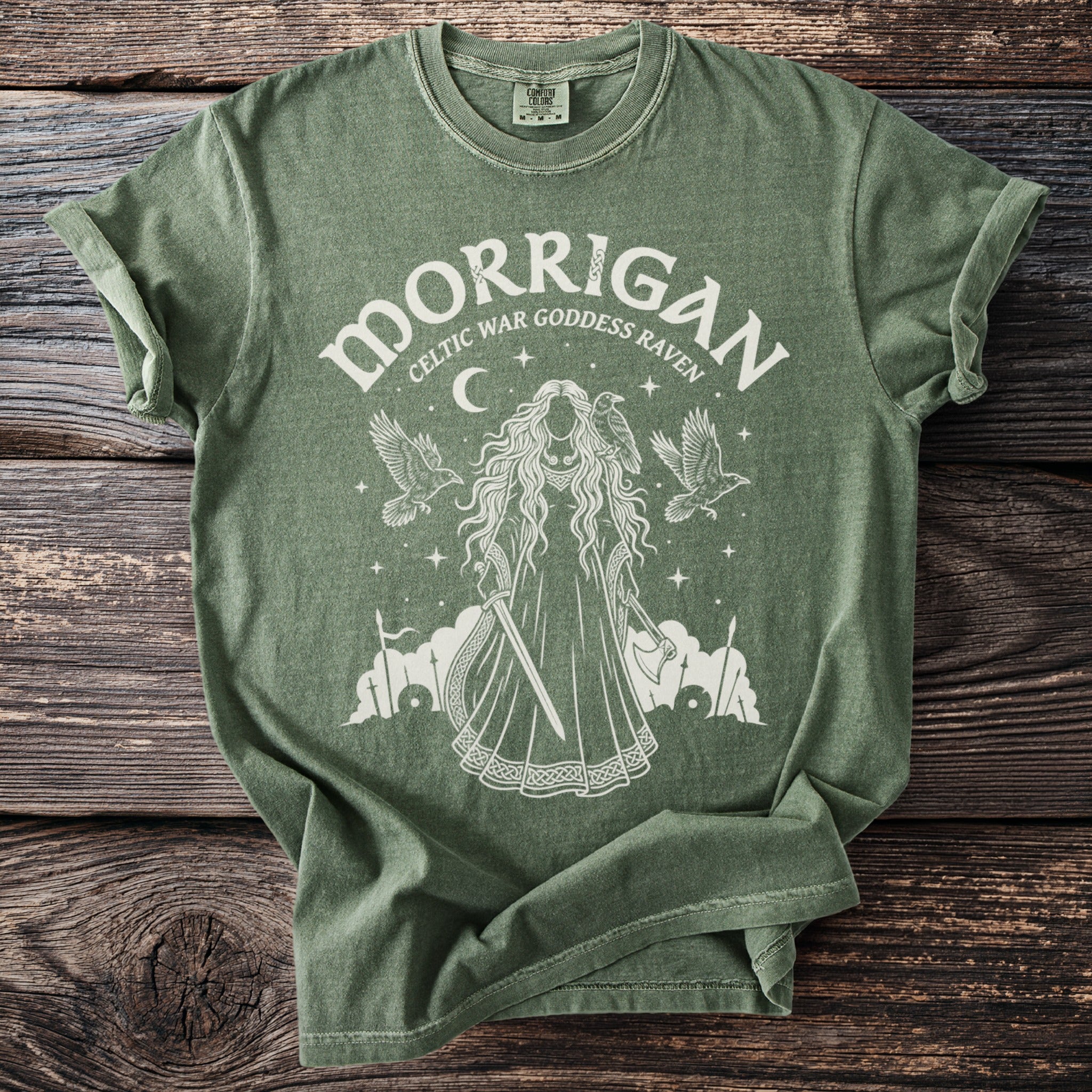 Green t-shirt with white graphic of Morrigan, Celtic war goddess raven.
