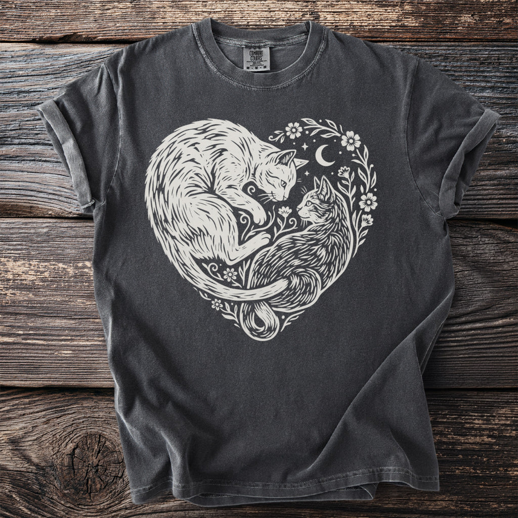 T-shirt with white linocut design of two cats in a heart shape, flowers, and crescent moon.
