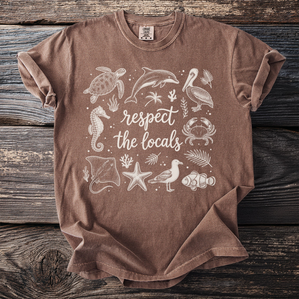 Brown t-shirt with white graphic of marine animals and text "respect the locals."