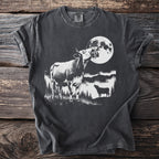 Dark t-shirt with a black and white graphic of cows under a large full moon.