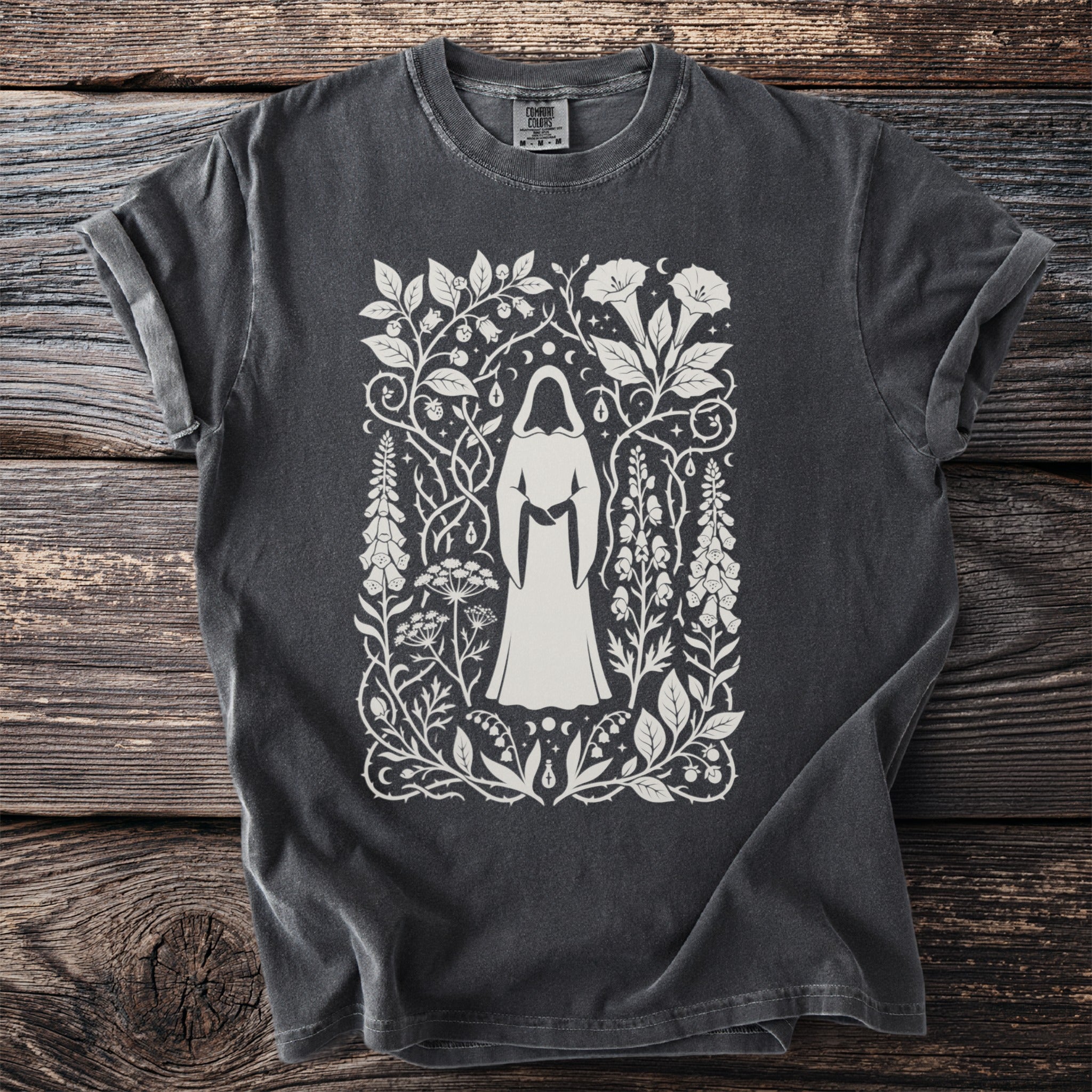 Dark grey t-shirt with a cream-colored occult-inspired botanical print featuring a hooded figure.