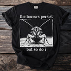 Black t-shirt with a cockroach graphic and text "the horrors persist but so do i".