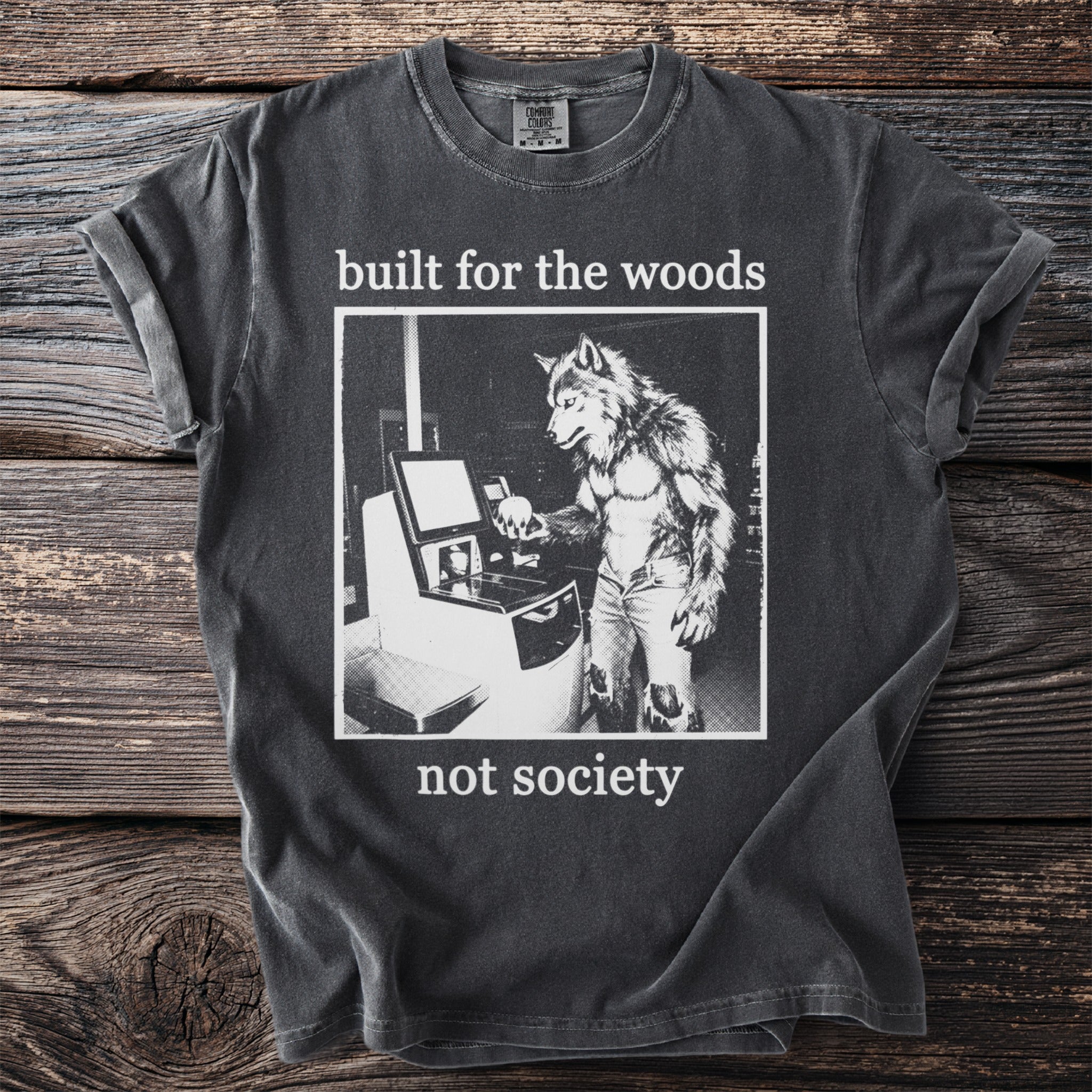 T-shirt with wolf-man at computer and text "built for the woods not society".