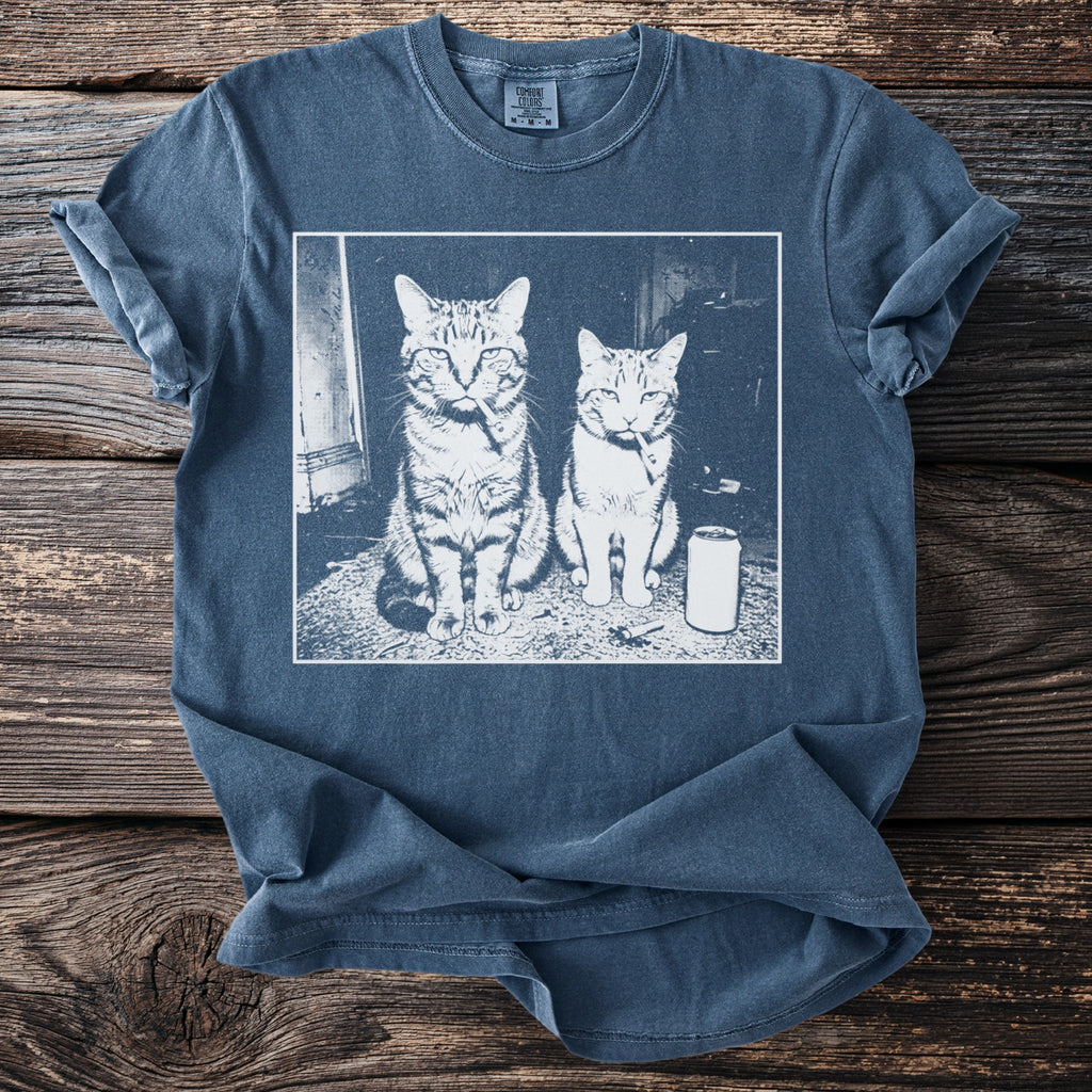 T-shirt with a graphic of two cats sitting with cigarettes in their mouths and a can.
