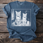 T-shirt with a graphic of two cats sitting with cigarettes in their mouths and a can.