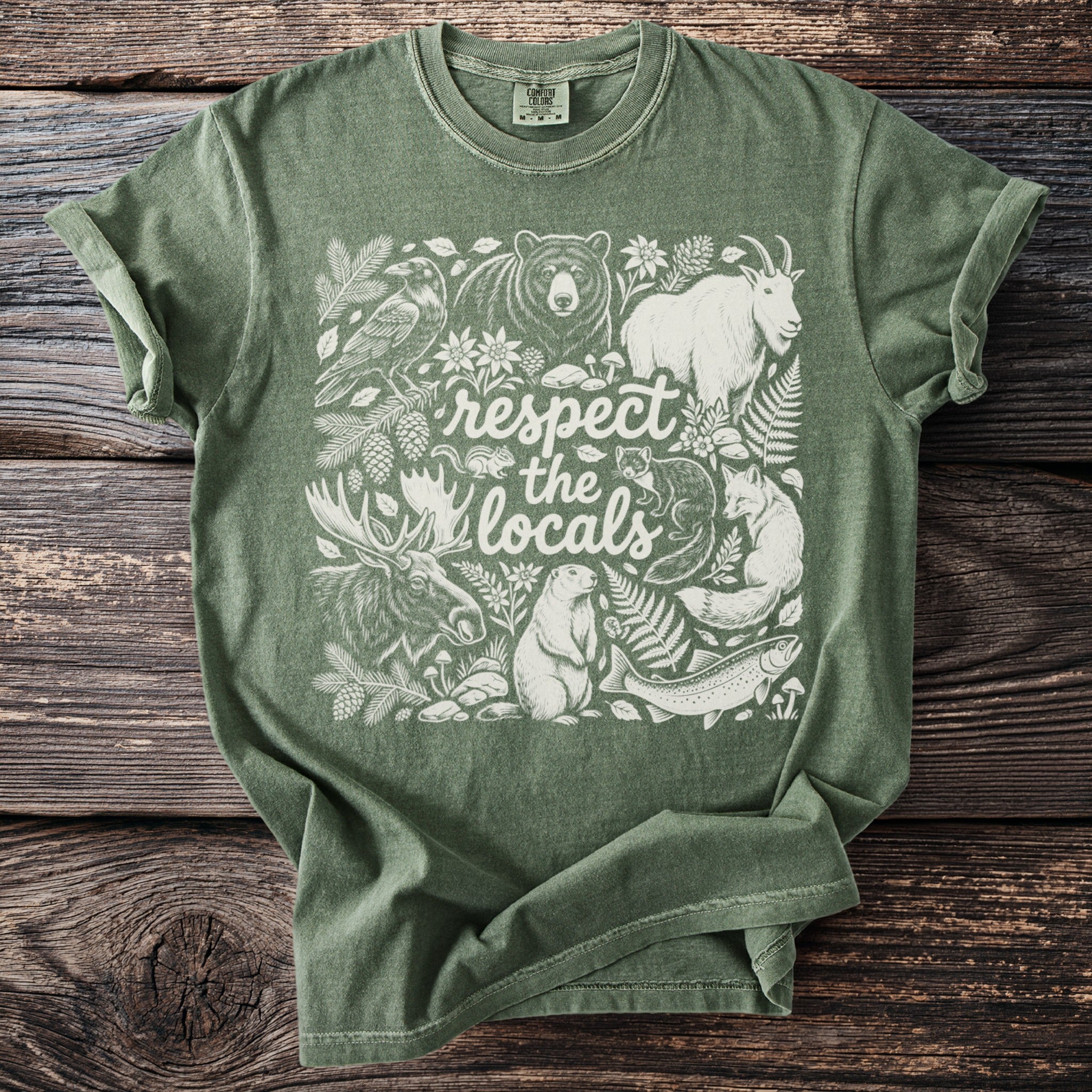 Green t-shirt with white woodland animals and "respect the locals" text design.