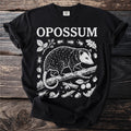 Black t-shirt with "OPOSSUM" text and opossum graphic with beetles, snail, acorns, and berries.