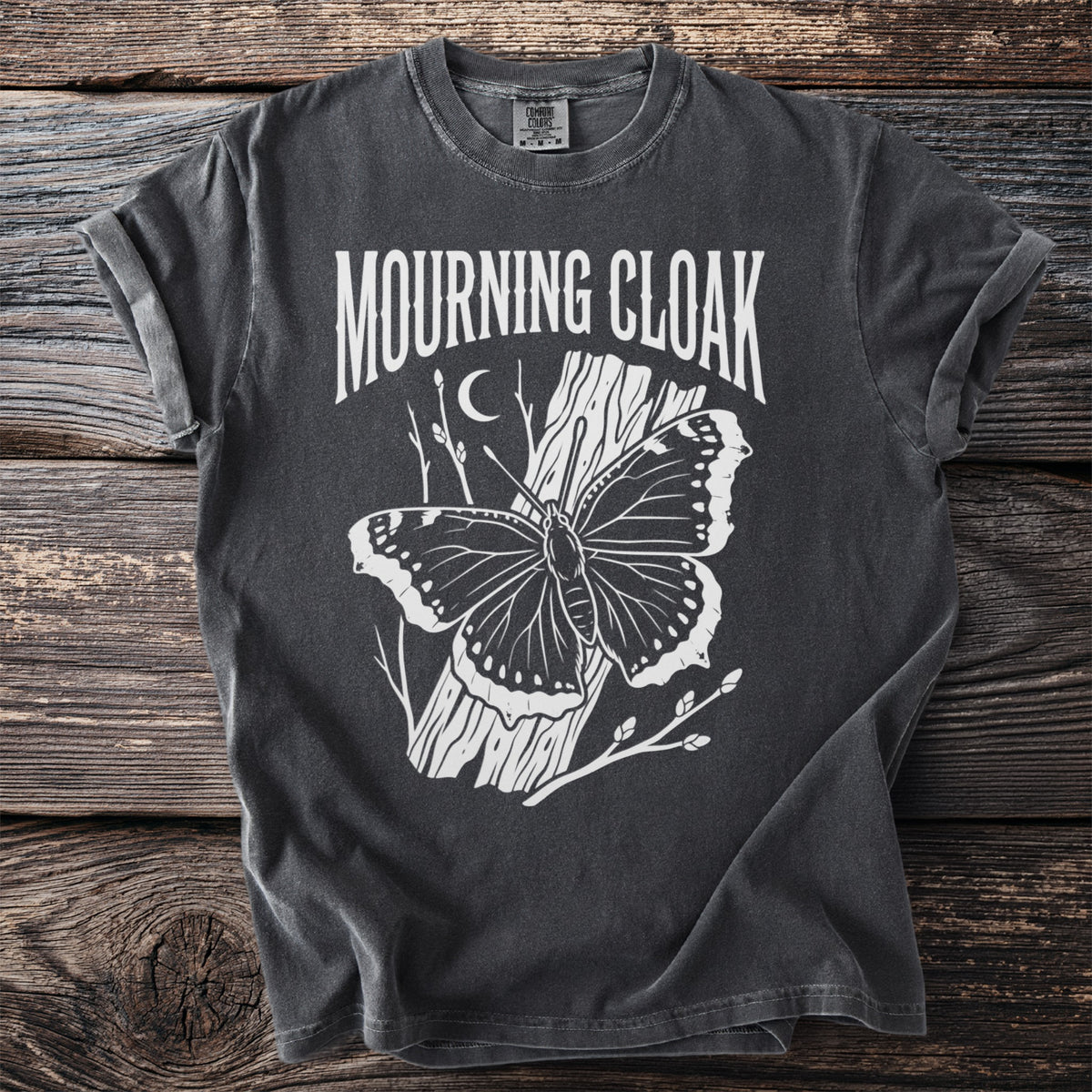 Dark gray t-shirt with "Mourning Cloak" text and a butterfly on a tree trunk.