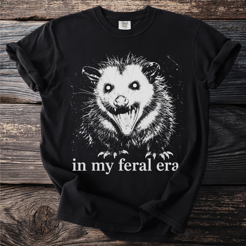 Black t-shirt with a white graphic of a screaming opossum and text "in my feral era".