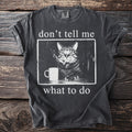 T-shirt graphic of a cat smoking a cigarette next to a mug with text.