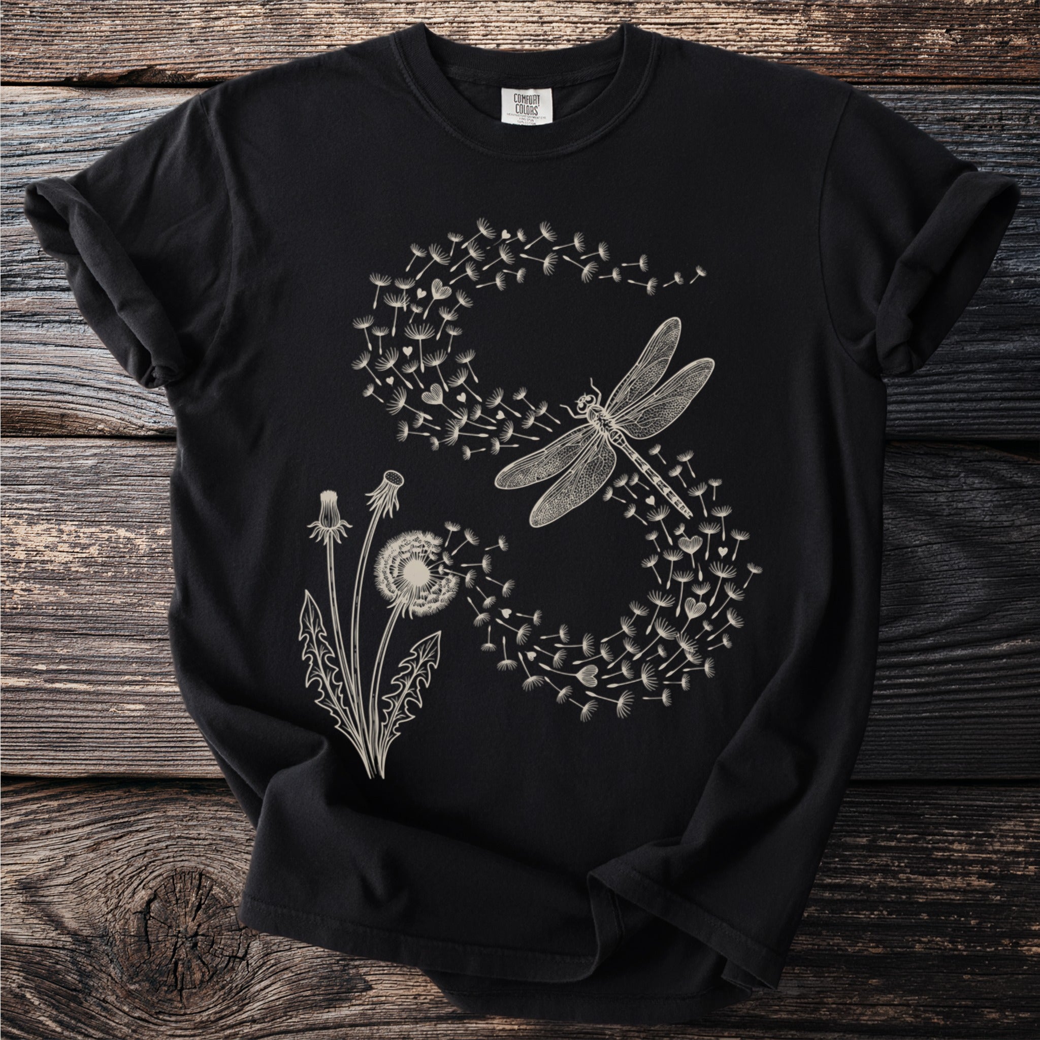 Black t-shirt with a cream-colored graphic of dandelions and a dragonfly.