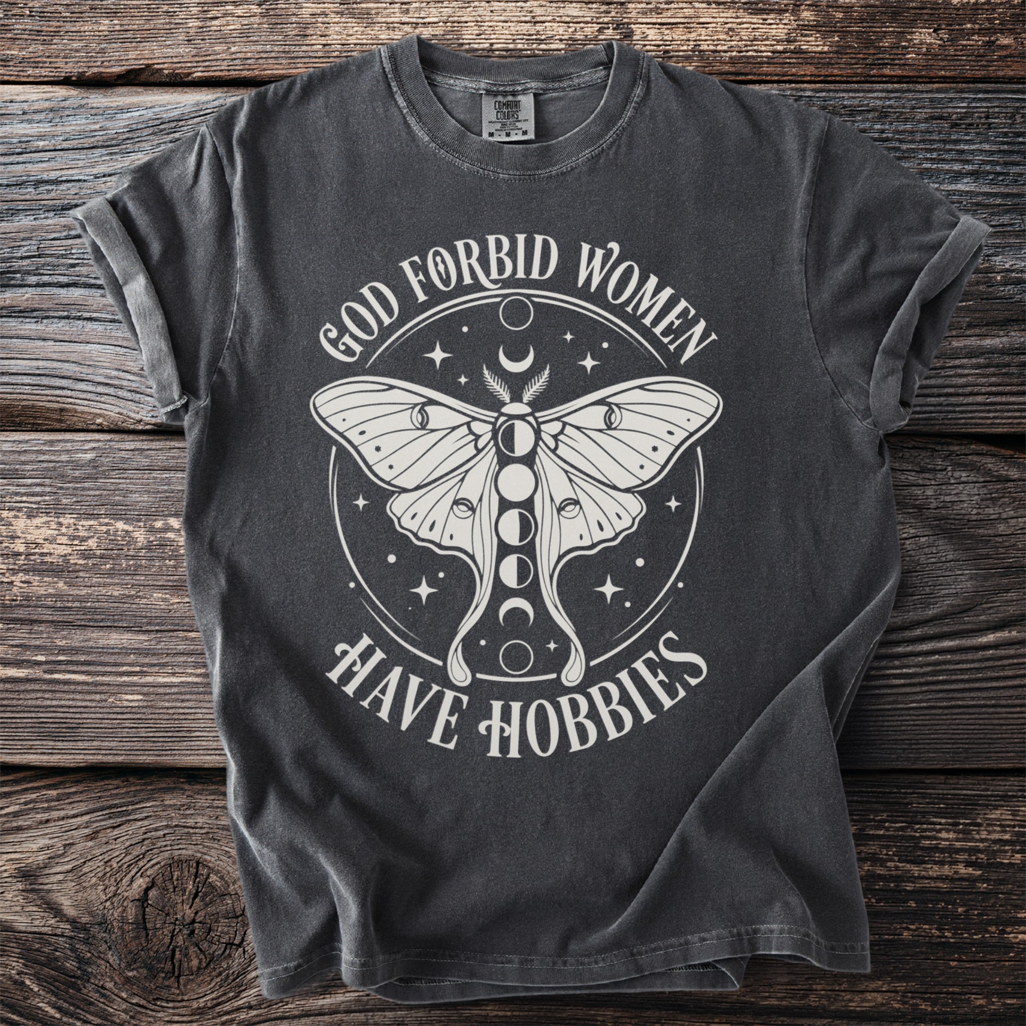Dark grey t-shirt with white text and graphics of a moth and moon phases.