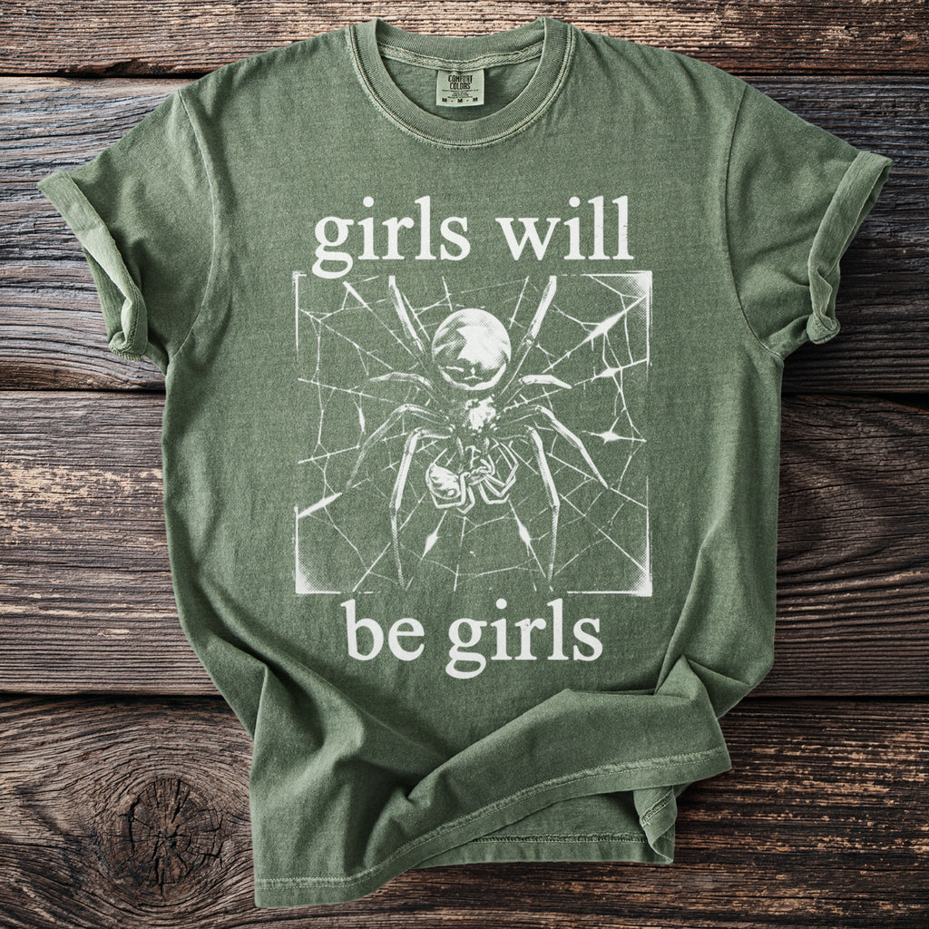Green t-shirt with spider on web graphic and "girls will be girls" text.