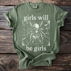 Green t-shirt with spider on web graphic and "girls will be girls" text.
