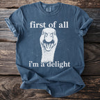 Blue T shirt with a goose and the text “first of all I’m a delight”.