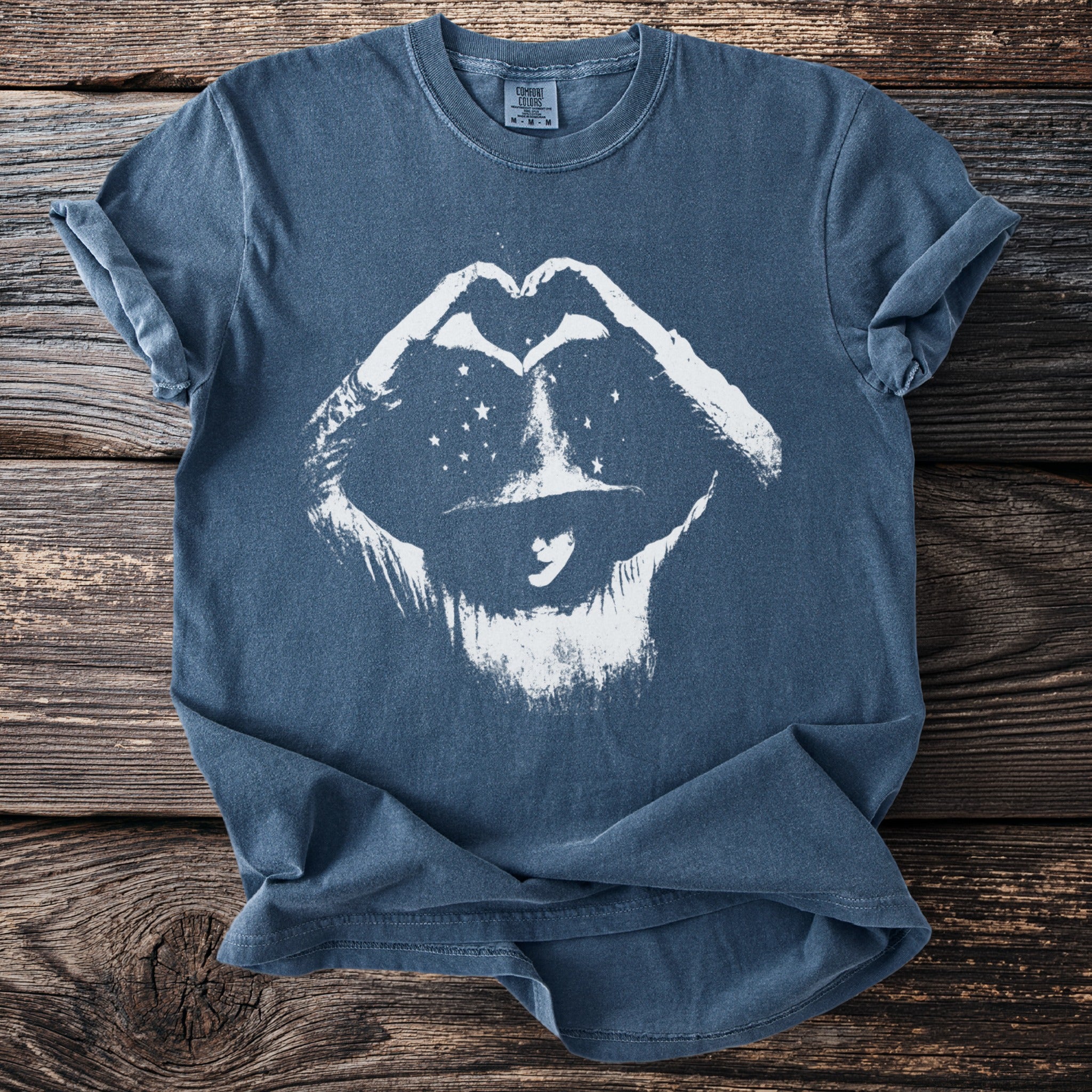 Blue Comfort Colors t-shirt with white graphic of lips forming a heart, wearing a hat.